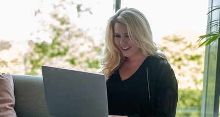 woman working with laptop and sitting on the couch