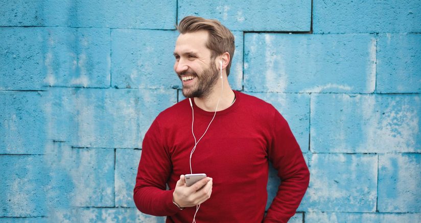 a man wearing earbuds and smiling