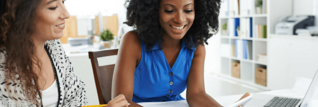 Two women engaging in sales training on an iPad and a Mac laptop