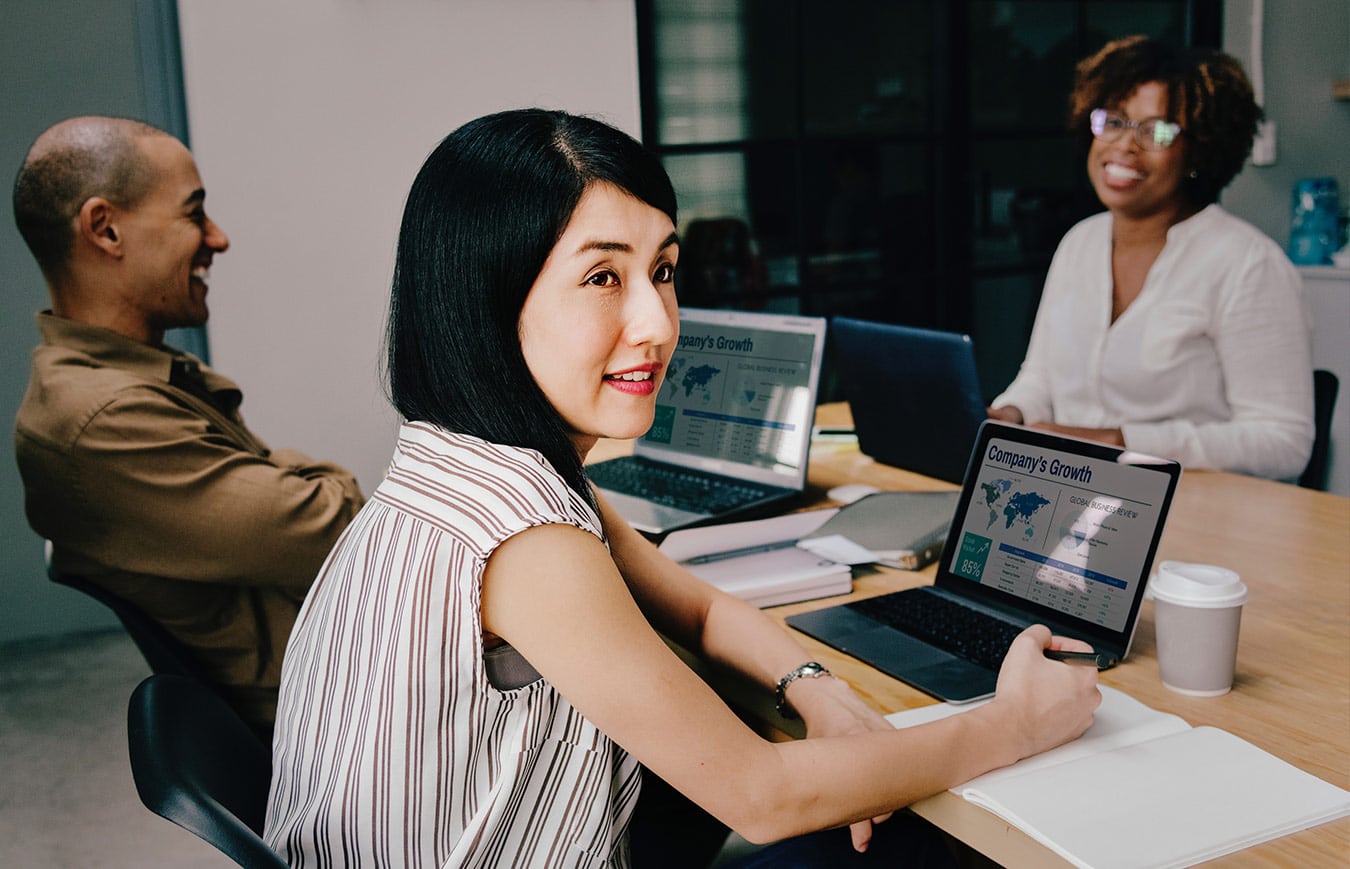 Woman sitting at the table and working on the laptop during the meeting