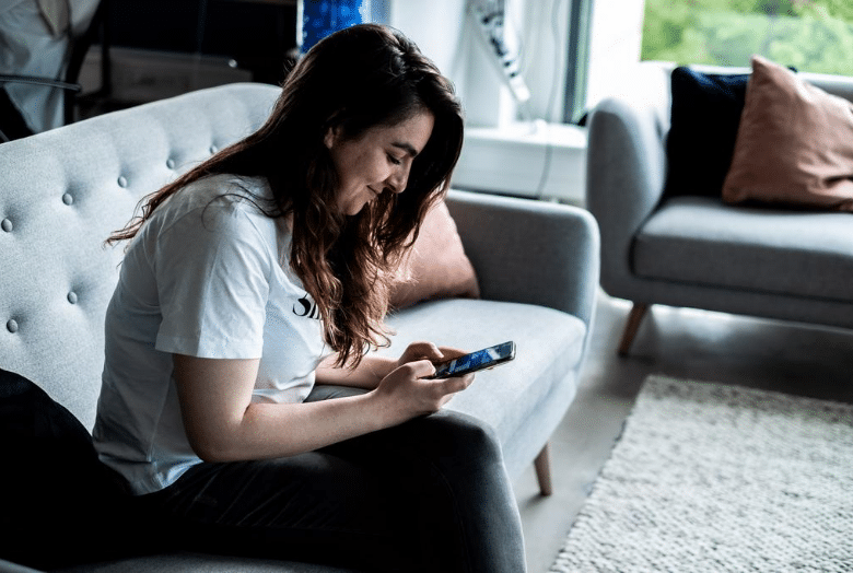 Girl sitting on her phone on a couch