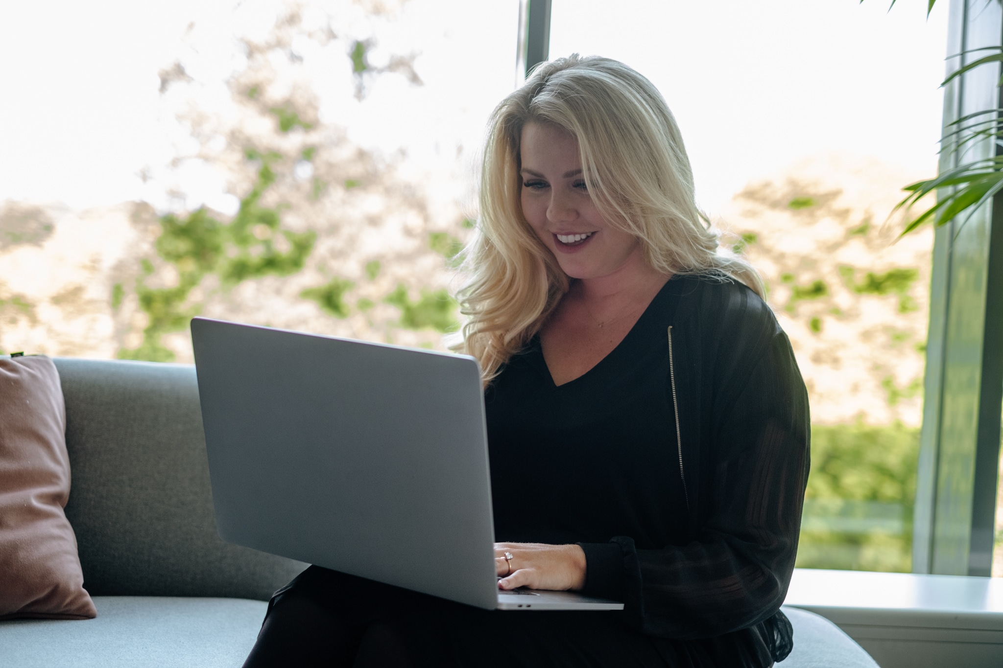 woman working with laptop and sitting on the couch