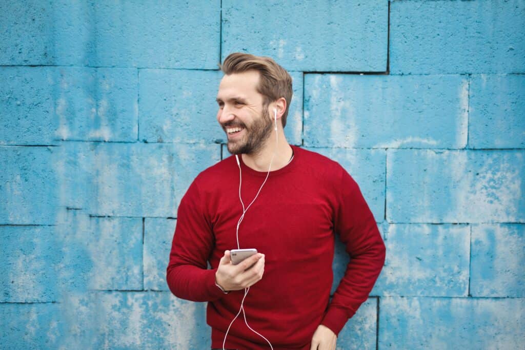 a man wearing earbuds and smiling